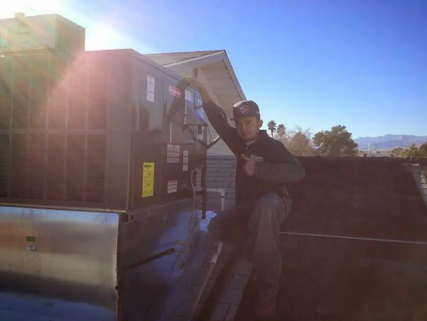 HVAC technician performing Boiler Repair on a rooftop unit in Merrimac